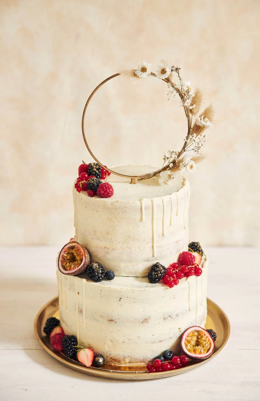 vertical shot wedding cake decorated with fresh fruits berries flower ring